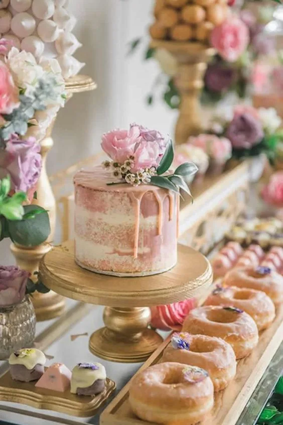 Mesa de dulces con postres decorados con flores